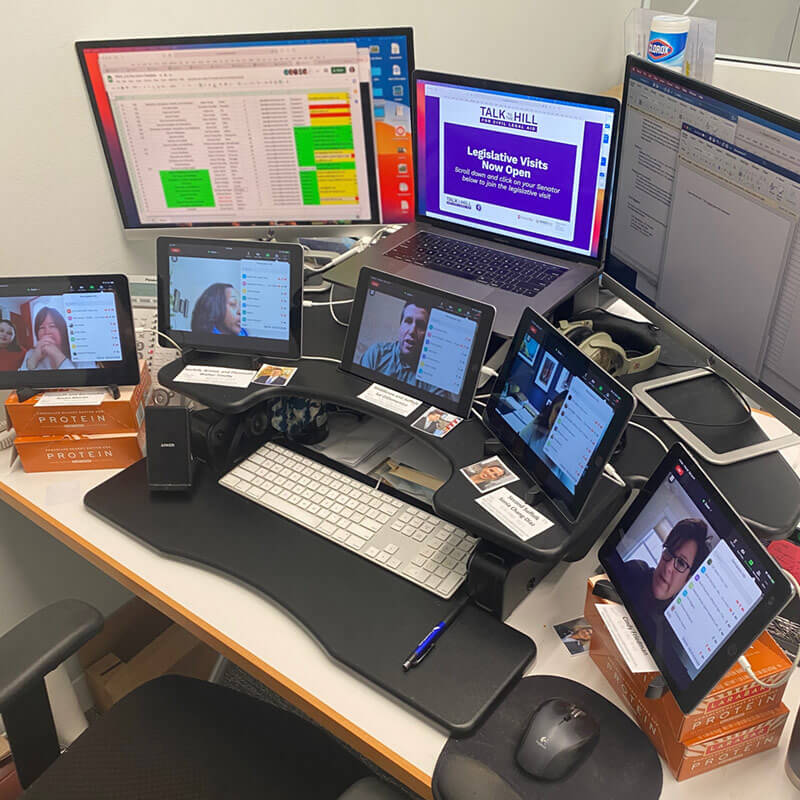 Computer and iPads set up in the Conventures office monitoring the Zoom rooms